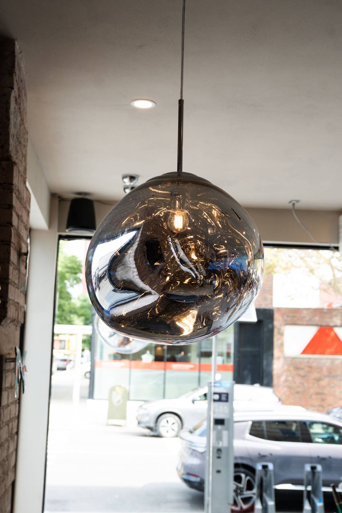 Smoke-glass pendant lamp over the storefront window