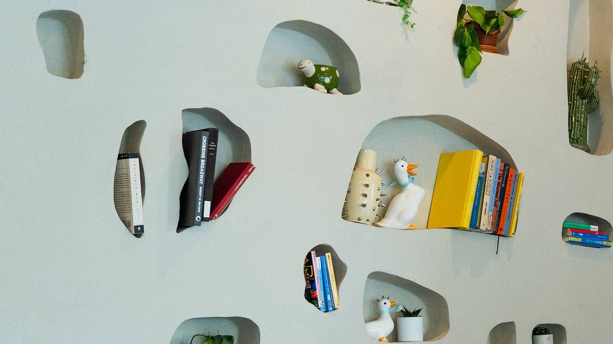 Carved wall niches with books and ceramic figurines