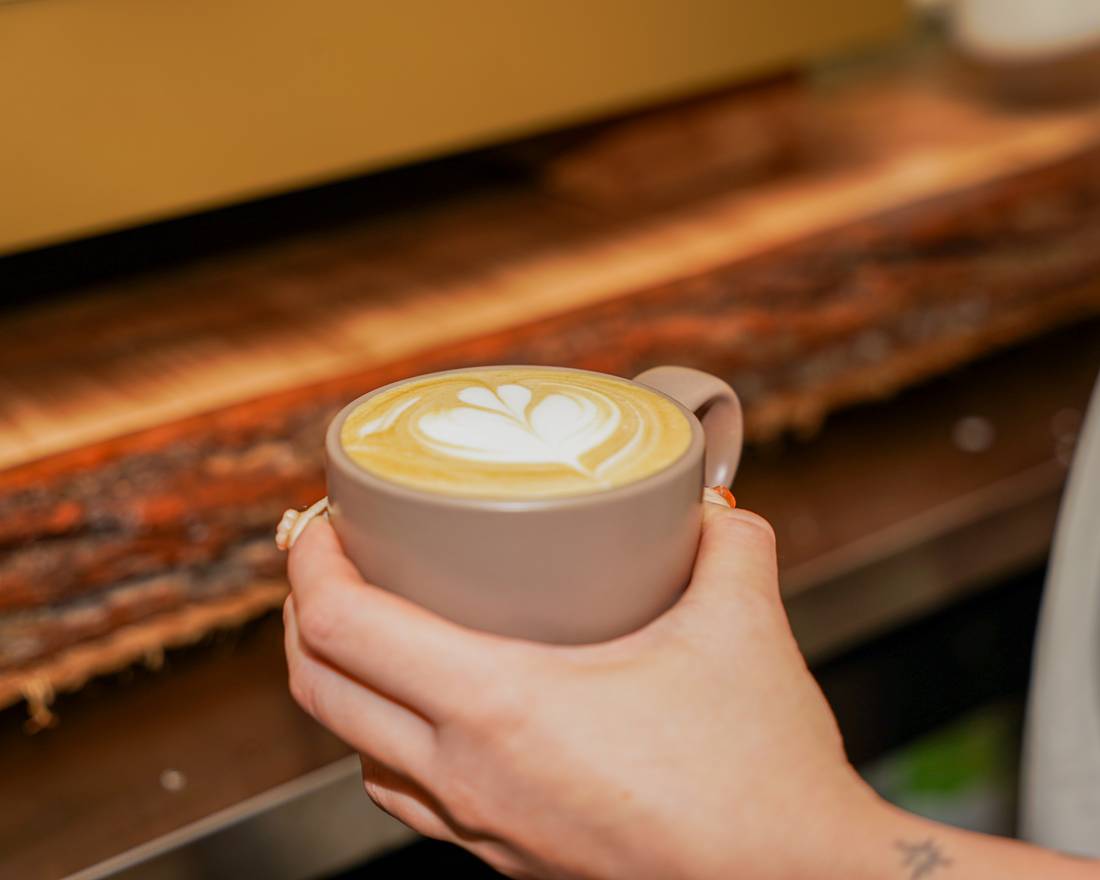 Iced matcha latte being poured at Nova Cafe